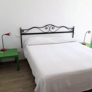 een slaapkamer met een wit bed en een groene tafel bij Mololocale in centro a Marcelli in Marcelli
