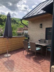 eine Terrasse mit einem Sonnenschirm, einem Tisch und Stühlen in der Unterkunft A modern Barn house in Brusno in Banská Bystrica