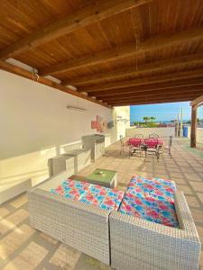 a patio with a table and chairs and a couch at Il Mare in Tasca - Casa Vacanze - loc.Torre Lapillo (LE) - Salento in Torre Lapillo