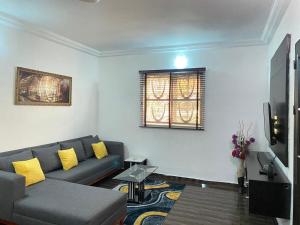 sala de estar con sofá y TV en KALMS APARTMENT, en Port Harcourt