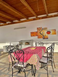 a dining room with a table and four chairs at Il Mare in Tasca - Casa Vacanze - loc.Torre Lapillo (LE) - Salento in Torre Lapillo