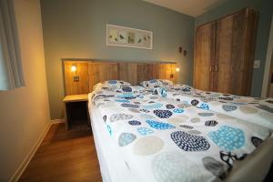 Appartement Am Postwiesen في وينتربرغ: سرير لحاف من اللون الأزرق والأبيض في غرفة النوم