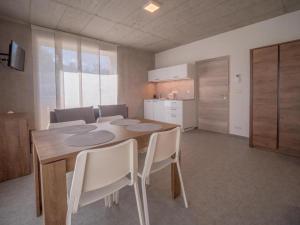 a dining room with a table and chairs and a kitchen at Apartmány Bílá Nisa in Bedřichov