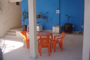 a table and chairs in a room with a blue wall at stellamares suites in Salvador