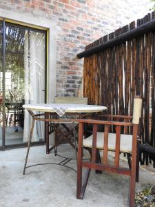 uma mesa e uma cadeira ao lado de uma parede de tijolos em Kruger KayaLakho em Marloth Park