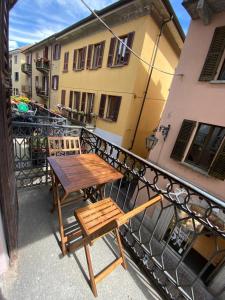 a wooden table and chairs on a balcony at La casa del corso in Arona