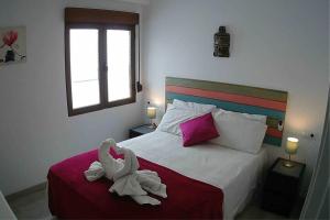 a bedroom with a bed with two swans on it at La Gaviota apartment, in the heart of the port in Jávea