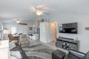 a living room with a couch and a tv at Three Palms Tree Home in Panama City Beach