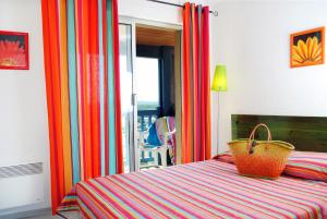 Un dormitorio con una cama con una cesta. en Résidence Néméa Les Gourbets, en Mimizan-Plage