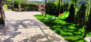 een tuin met een groen gazon met een groene schommel bij Apartment Wine & Olive oil Mofardin in Koper