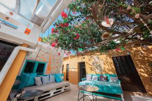 Habitación con sofá y árbol en Orange Terrace Hostel en Albufeira