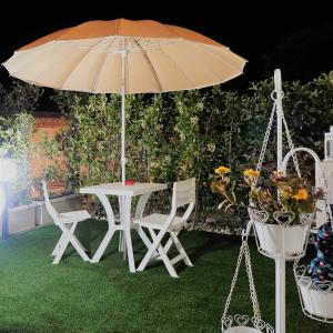マテーラにあるLa Dolce Notteのテーブルと椅子、傘、植物