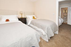 a bedroom with two beds with white sheets at The Fountain Inn in Leek