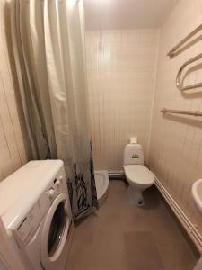 uma casa de banho com um WC e uma máquina de lavar roupa em Estonia pst 26 em Kohtla-Järve