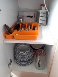 utensilios de cocina en una bandeja naranja en un estante en Estonia pst 26, en Kohtla-Järve
