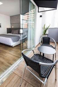 um quarto com uma cama, uma mesa e uma cadeira em Tropikalya Gold Hotel em Balneário Camboriú