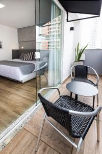 a bedroom with a bed and a table and a chair at Tropikalya Gold Hotel in Balneário Camboriú