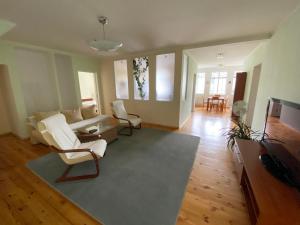 a living room with a white couch and chairs at Family Apartments in Jūrmala