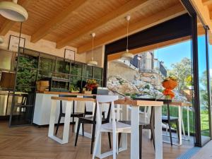 a kitchen with white tables and chairs and a large window at Elle Ecoholiday in Malcesine