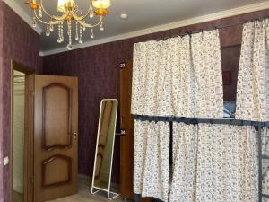 Gur'yevskにあるLa Belle отель ресторанのカーテンとドア、シャンデリアが備わるお部屋
