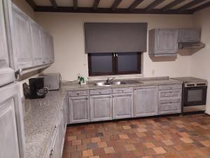 胡塔伦Surrender three bedrooms的厨房配有白色橱柜、水槽和炉灶