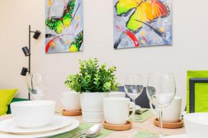 a dining room table with white dishes and wine glasses at Apartament Zielony Sopot Karlikowo by Renters in Sopot