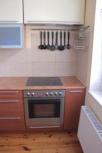 a kitchen with a stove and utensils on the wall at Family Apartments in Jūrmala