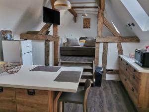 a kitchen and living room with a table and a couch at Bi d'Grosseltere Gîtes de charme in Kirrwiller