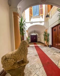Ein Gebäudeflur mit rotem Teppich und einer Statue in der Unterkunft Casa Manfredi D'Angiò in Manfredonia