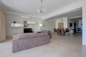 Una sala de estar con un sofá y un comedor. en SEAFRONT LUX APART inc POOL, Upmarket Area, en Sliema