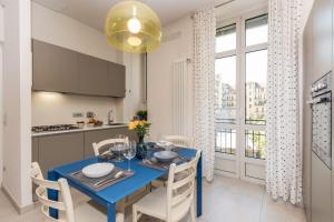 a kitchen and dining room with a blue table and chairs at Appartamento nel cuore di Crocetta by Wonderful Italy in Turin