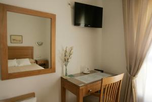 
a bedroom with a television and a dresser at Hotel Goartín in Málaga
