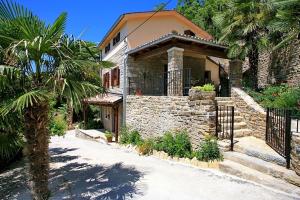 una casa de piedra con una palmera delante de ella en Villa Aurora, en Livade