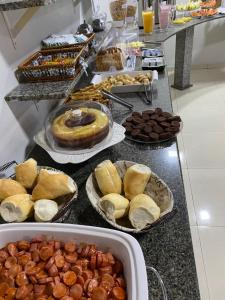um buffet repleto de diferentes tipos de comida e sobremesas em Avenida Center Hotel em Uruguaiana