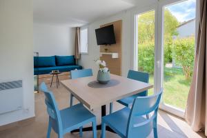 uma sala de jantar com uma mesa e cadeiras azuis em Zenitude Hôtel-Résidences Mandelieu la Napoule em Mandelieu-la-Napoule