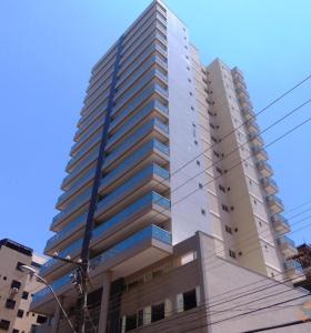 un grand bâtiment blanc dans une rue de la ville dans l'établissement Edifício Gil Nogueira, apartamento aconchegantes, piscina, sauna, Wiff, duas vagas de garagem., à Guarapari