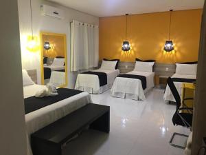 a hotel room with three beds and a mirror at Rossi Hotel in Comodoro