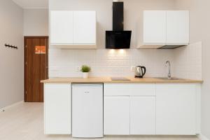 a white kitchen with white cabinets and a sink at Apartments Gdynia Abrahama in Gdynia