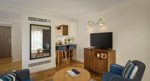 a living room with a television and a table at Citadines Barbican London in London
