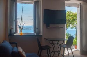 un soggiorno con tavolo, sedie e finestra di Kiwi Studio a Opatija