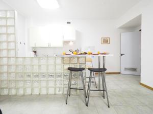 a kitchen with two bar stools and a counter at DIMORA SOTTORIPA DI FRONTE ALL ACQUARIO - GENOVABNB it in Genoa