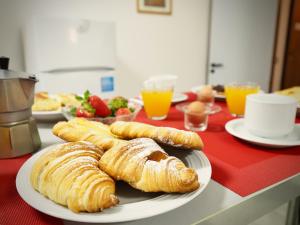 a plate of croissants on a table with orange juice at DIMORA SOTTORIPA DI FRONTE ALL ACQUARIO - GENOVABNB it in Genoa