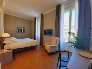 1 dormitorio con 1 cama, 1 silla y 1 ventana en SantAgata bed&breakfast en Como