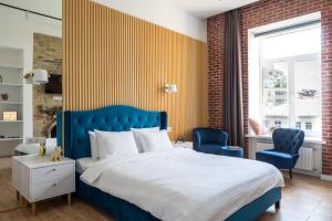 a bedroom with a blue bed and two blue chairs at Proreznaya Apartments in Kyiv
