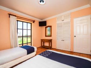 a bedroom with two beds and a window at Hotel La Casa Don Tito in Jocotitlán