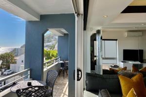 Clifton YOLO Spaces - Clifton Beachfront Executive Apartment في كيب تاون: شرفة مطلة على غرفة معيشة