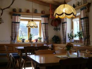 ein Esszimmer mit Tischen, Stühlen und Fenstern in der Unterkunft Gästehaus Baltram in Ramsau bei Berchtesgaden