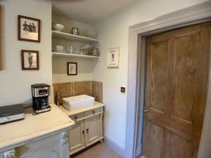a kitchen with a counter with a coffee maker on it at HORTUS HOUSE - Regency style apartment with attached parking in Brixham