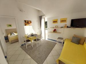 Una sala de estar con un sofá amarillo y una mesa. en Villa Kale Apartments, en Slatine