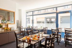 a dining room with a table with food on it at The Originals City, Hôtel Notre Dame, Rouen in Rouen